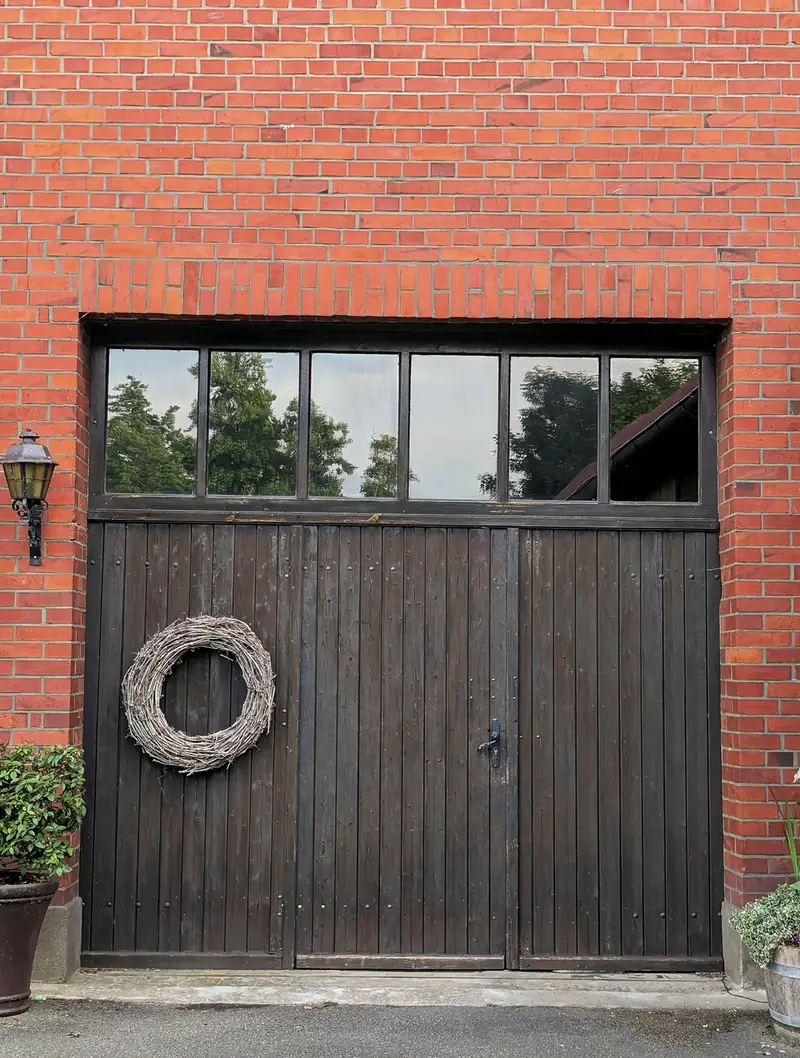 New carriage-house style wooden garage door with windows set in a brick Fall River, MA home