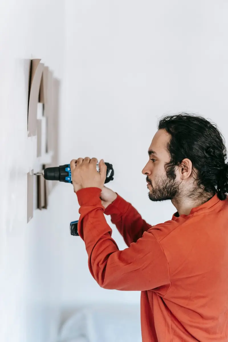 Technician using a cordless drill during a garage door repair in Fall River, MA